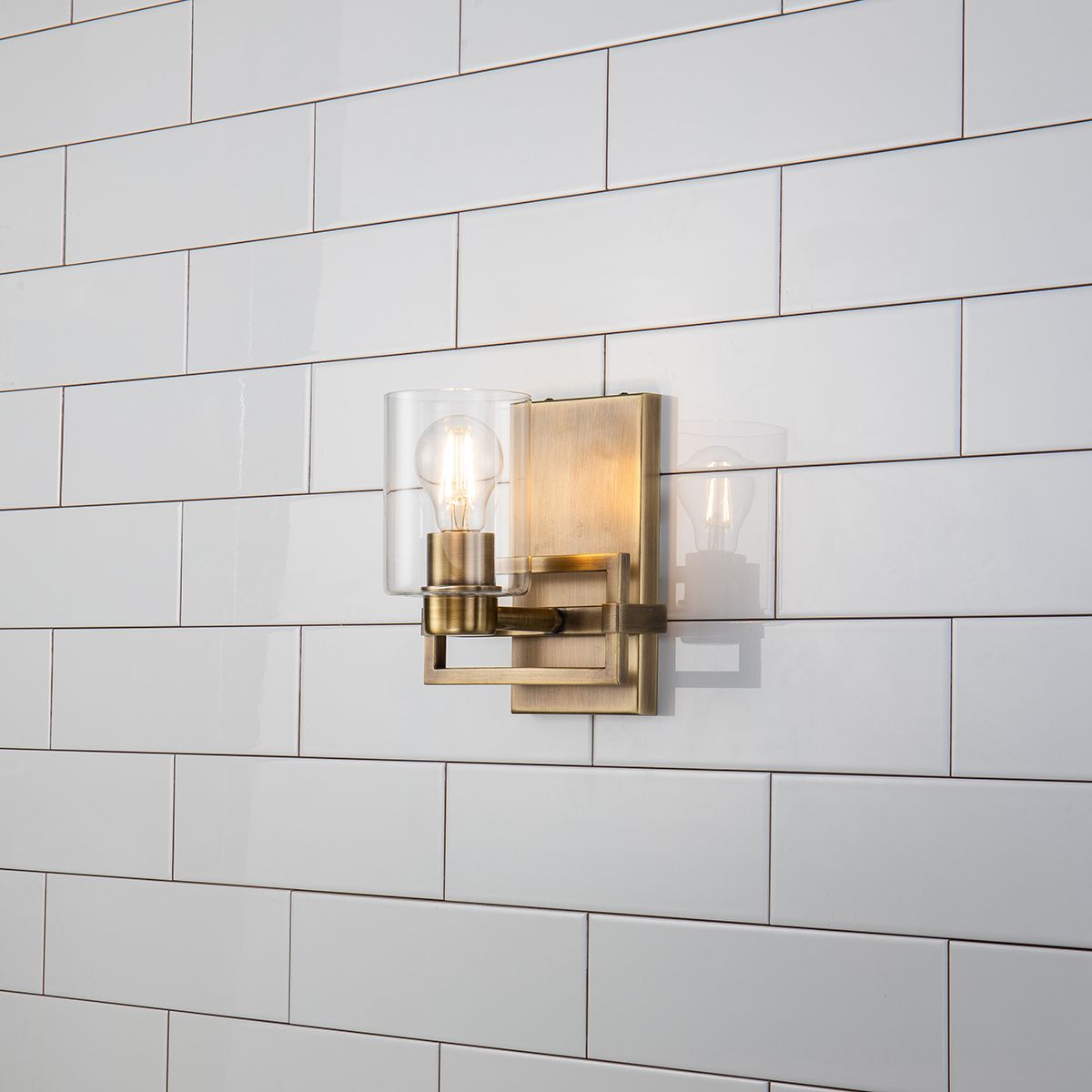 Lucas & McKearn Estes 1-Light Antique Brass Wall Light With Cylinder Shape Clear Glass Shade